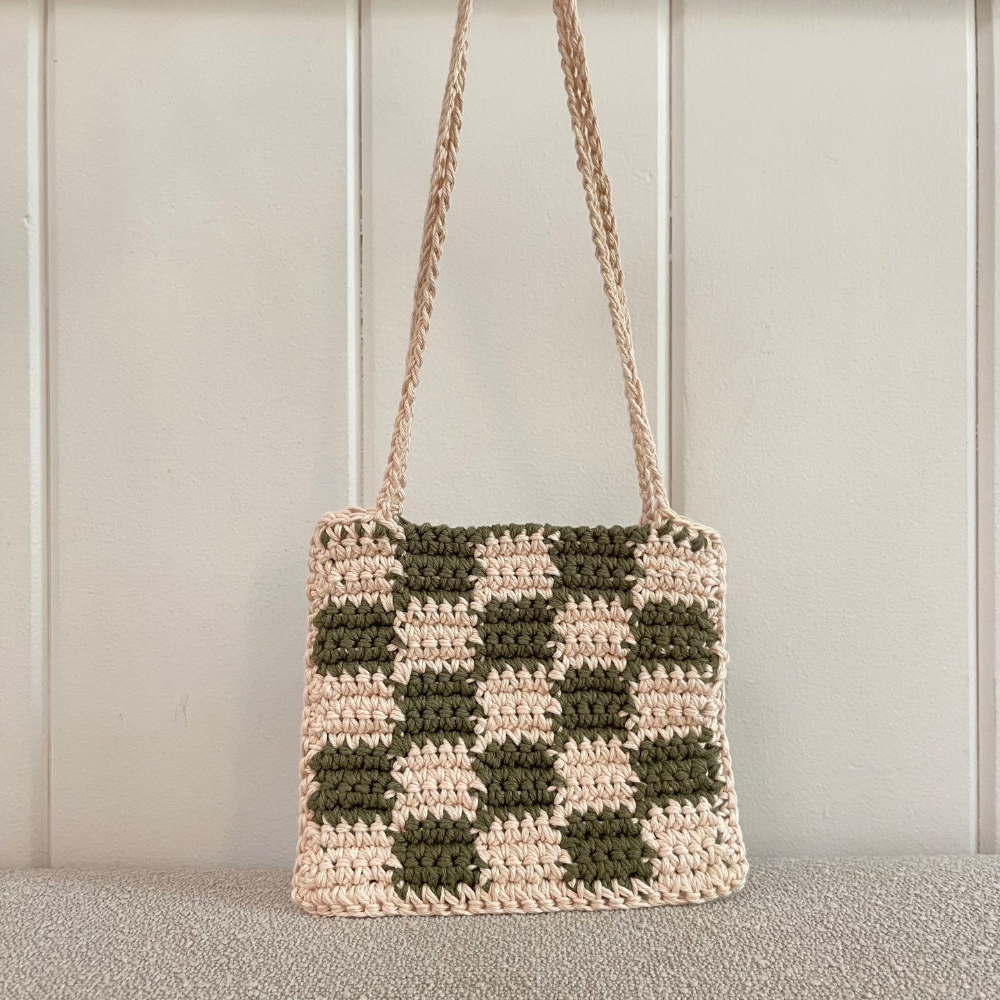 A checkered crochet shoulder bag in green and cream. 