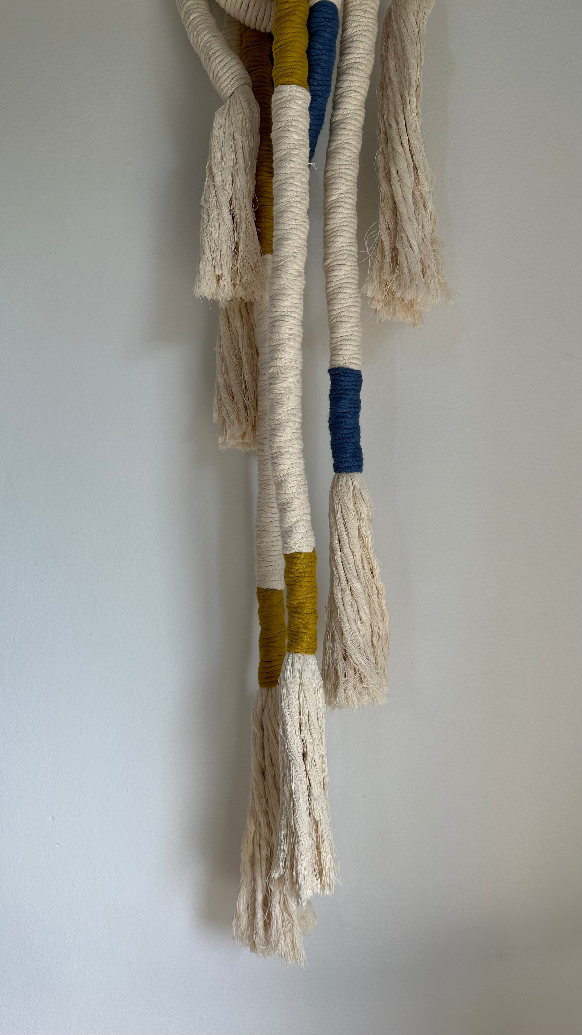 Wrapped Wall Hanging in white, blue, and yellow. 