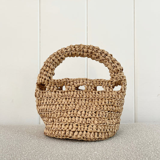 A picture of a Crochet handbag. A great addition to any neutral wardrobe.   Measures 6" wide x 9" tall + a hand strap. Made of raffia  
