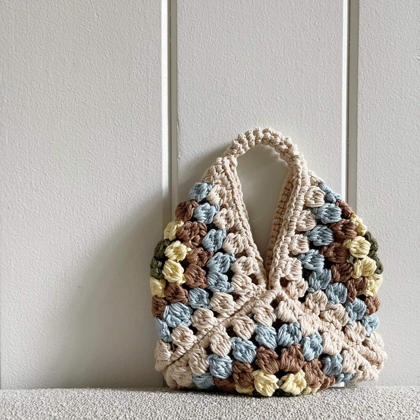 rochet granny square handbag  Measures 11 by 9 inches. Made of 100% cotton in colors cream, baby blue, light brown, light yellow and military green. 